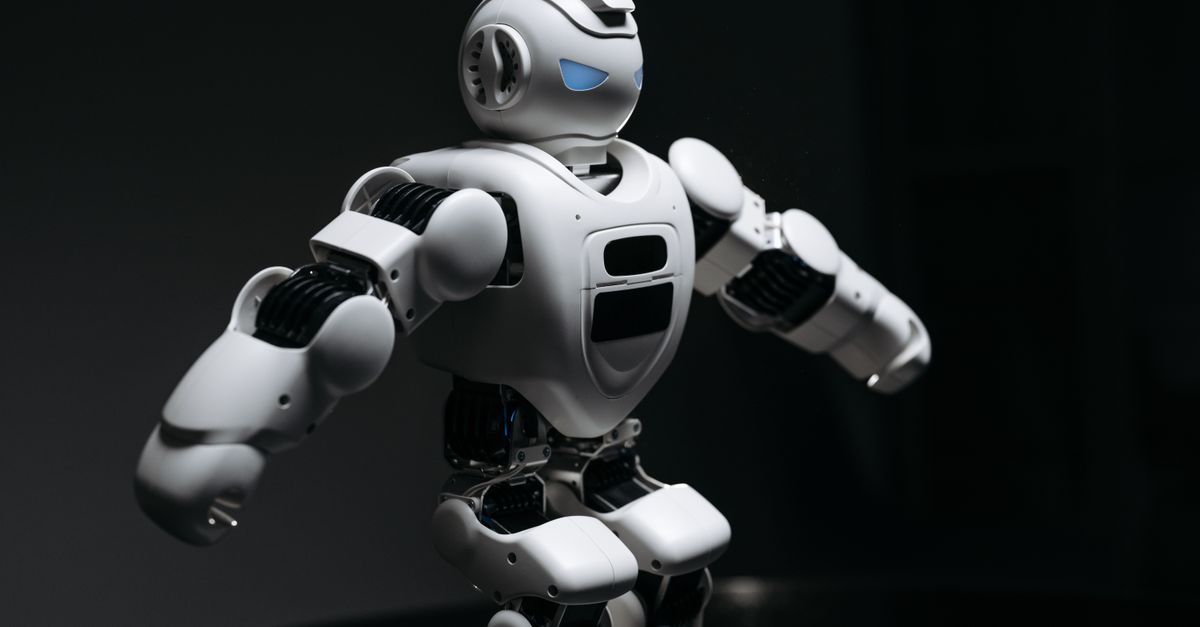 Close-up of a futuristic humanoid robot under dramatic lighting in dark ambiance.